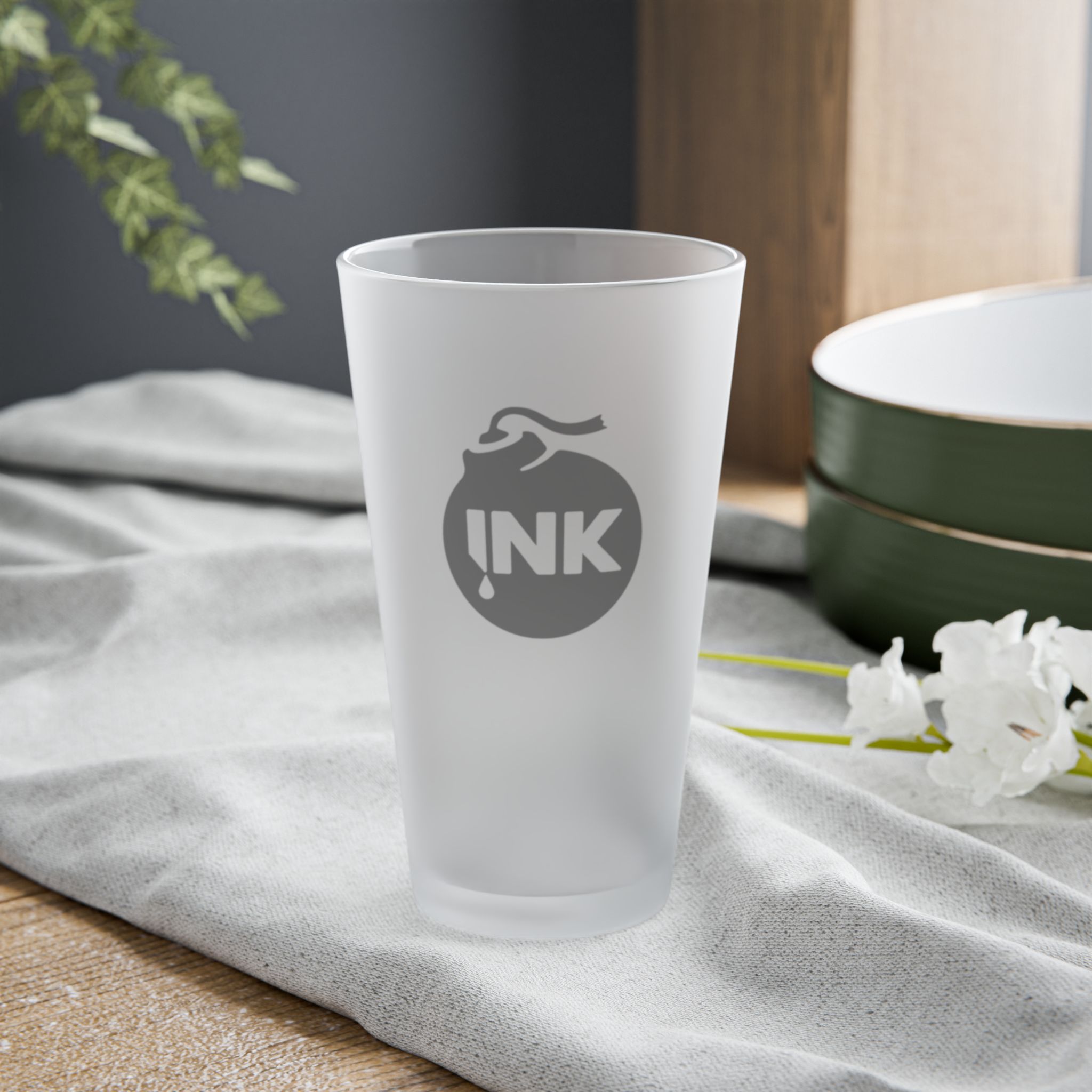Product photography of the InkBomb Frosted 16oz. Pint Glass sitting on a table